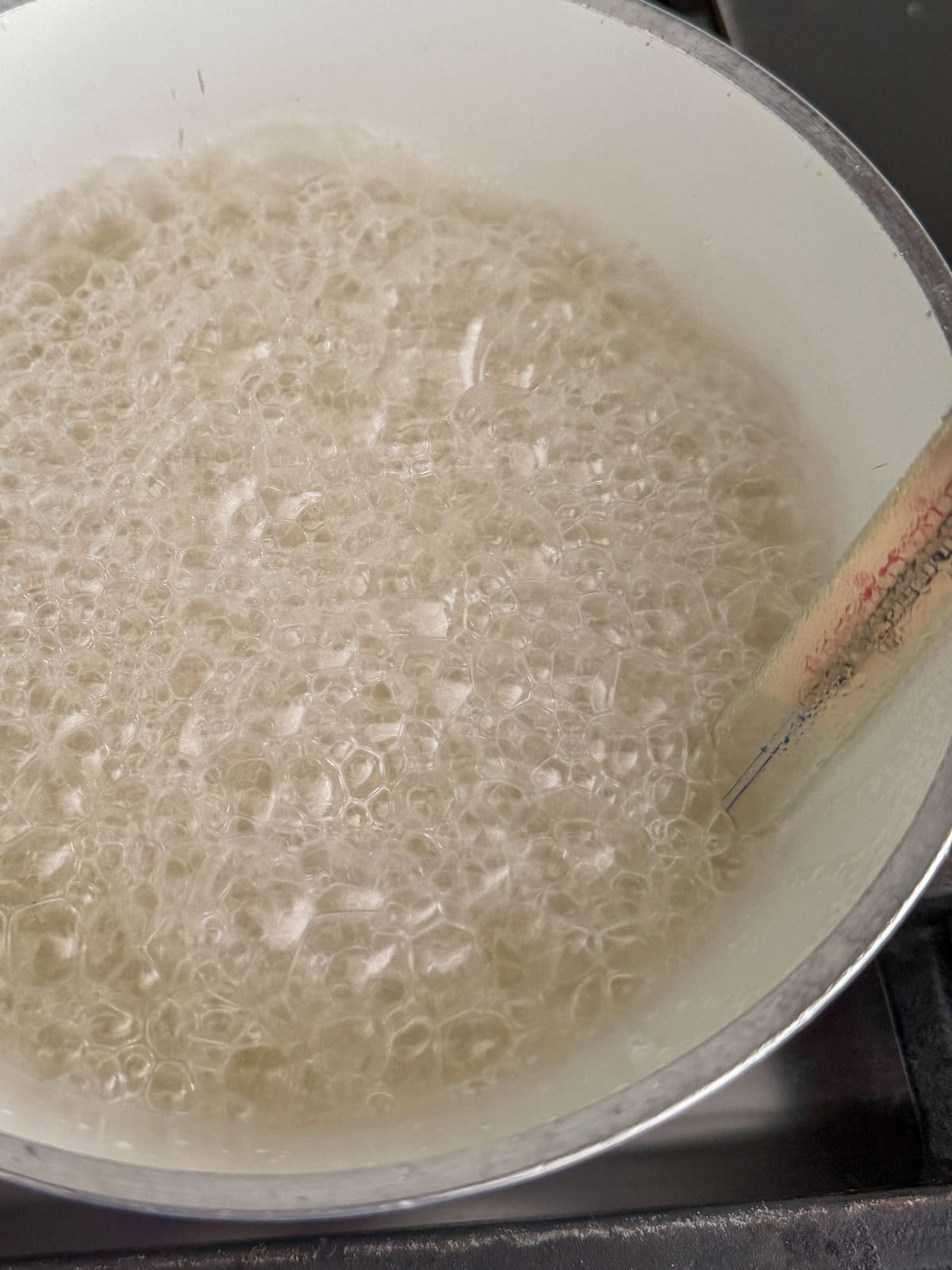 Sugar syrup boiling with a candy thermometer.