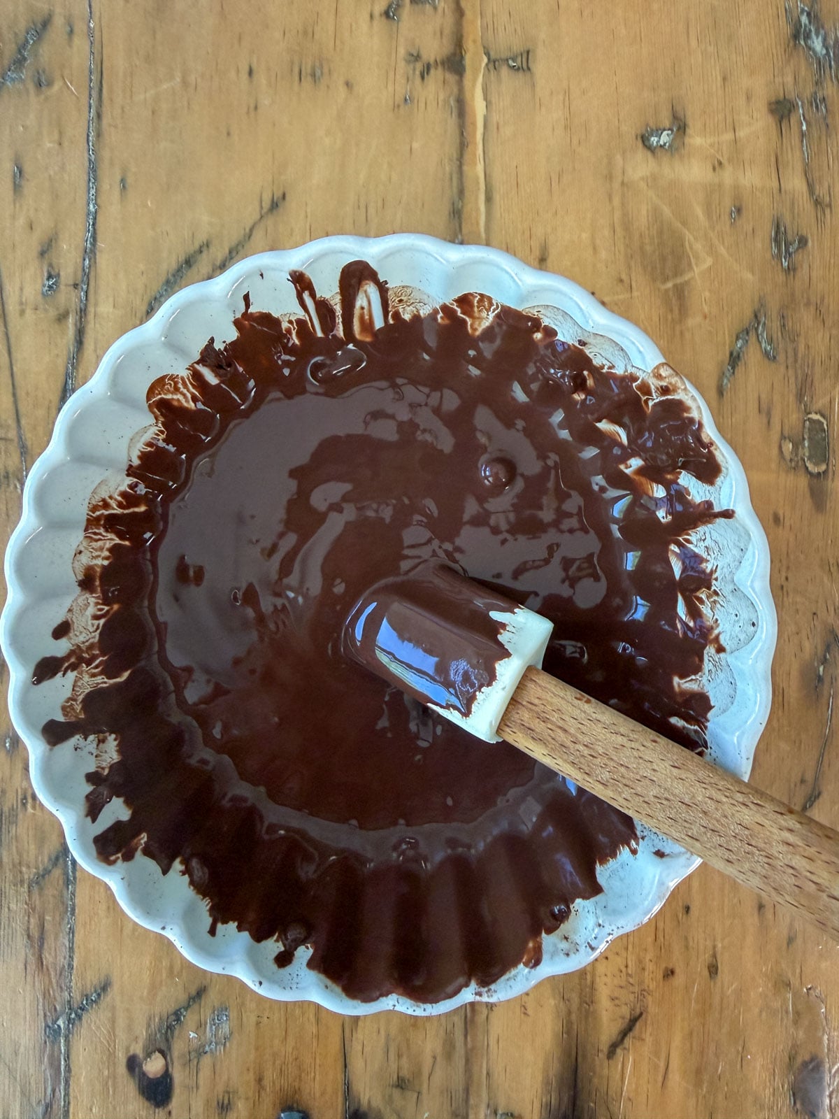 Bloomed cocoa paste in a bowl with a spatula.