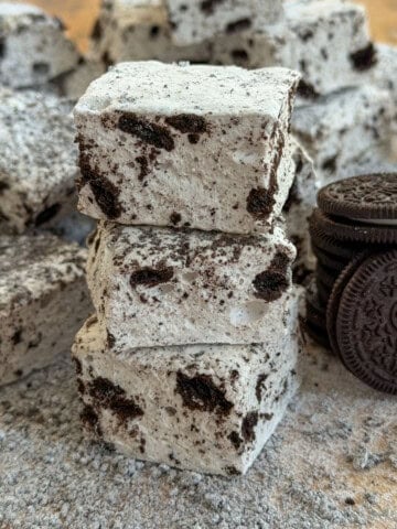 Stack of Oreo marshmallows with cookies and cream coating next to whole Oreo cookies.