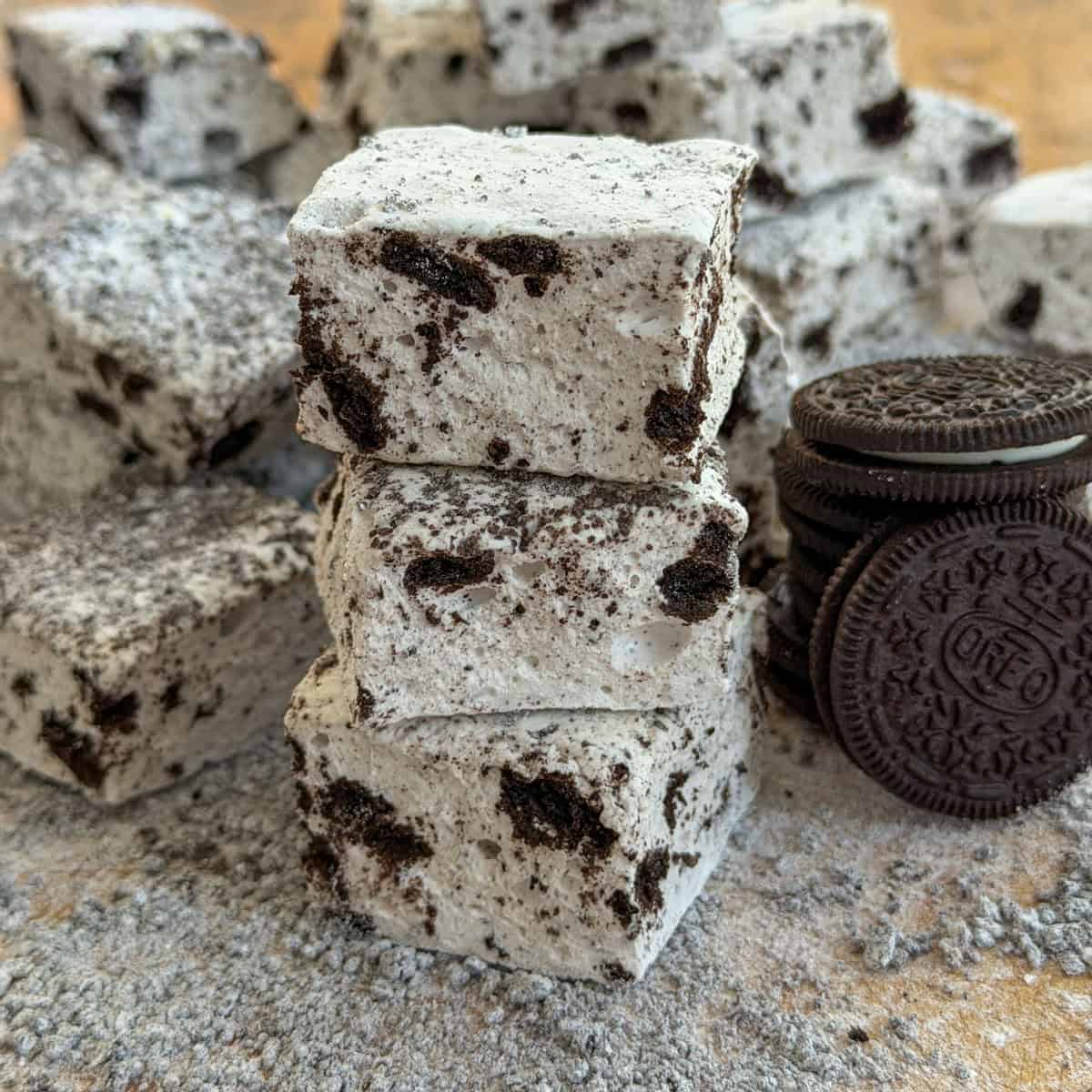 Stack of Oreo marshmallows with cookies and cream coating next to whole Oreo cookies.
