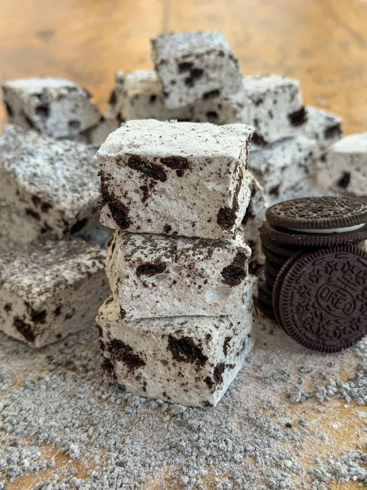 Stack of Oreo marshmallows with cookies and cream coating next to whole Oreo cookies.