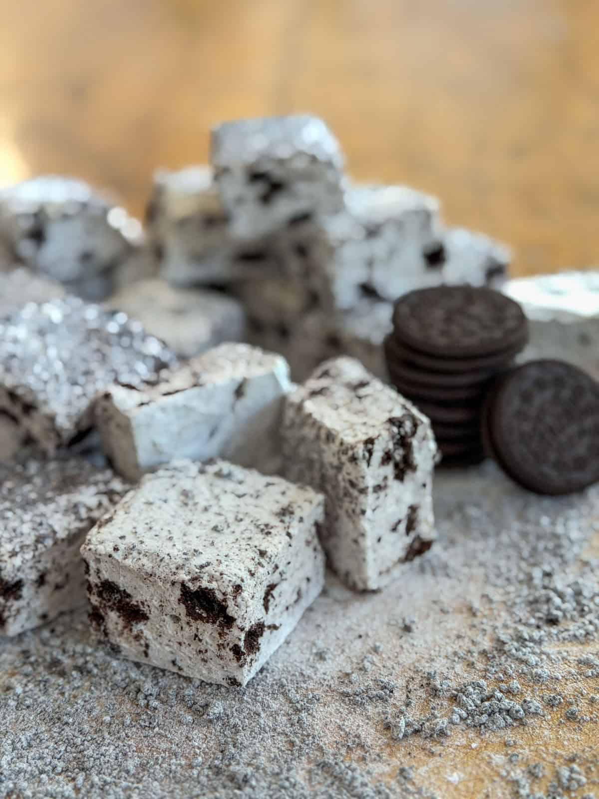 Oreo marshmallow squares stacked with Oreo cookies in the background.