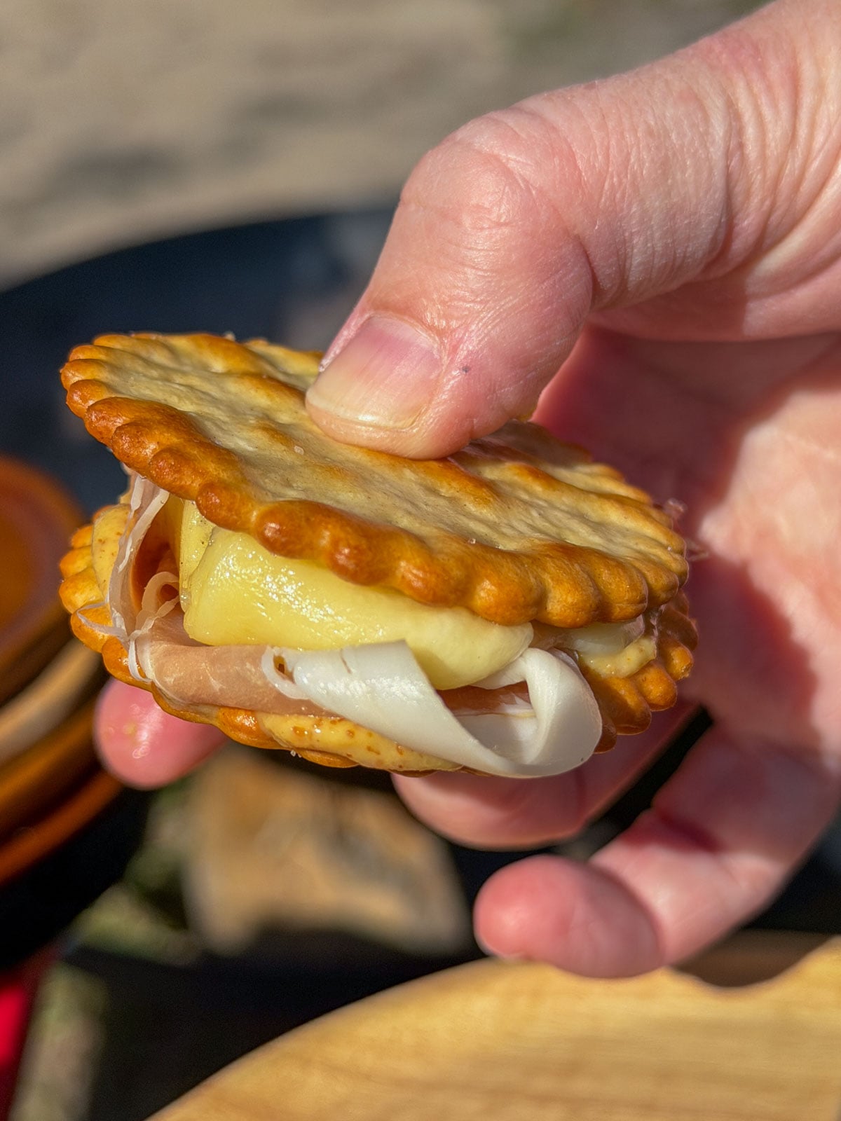 Melted Swiss cheese pulled apart between two crackers.
