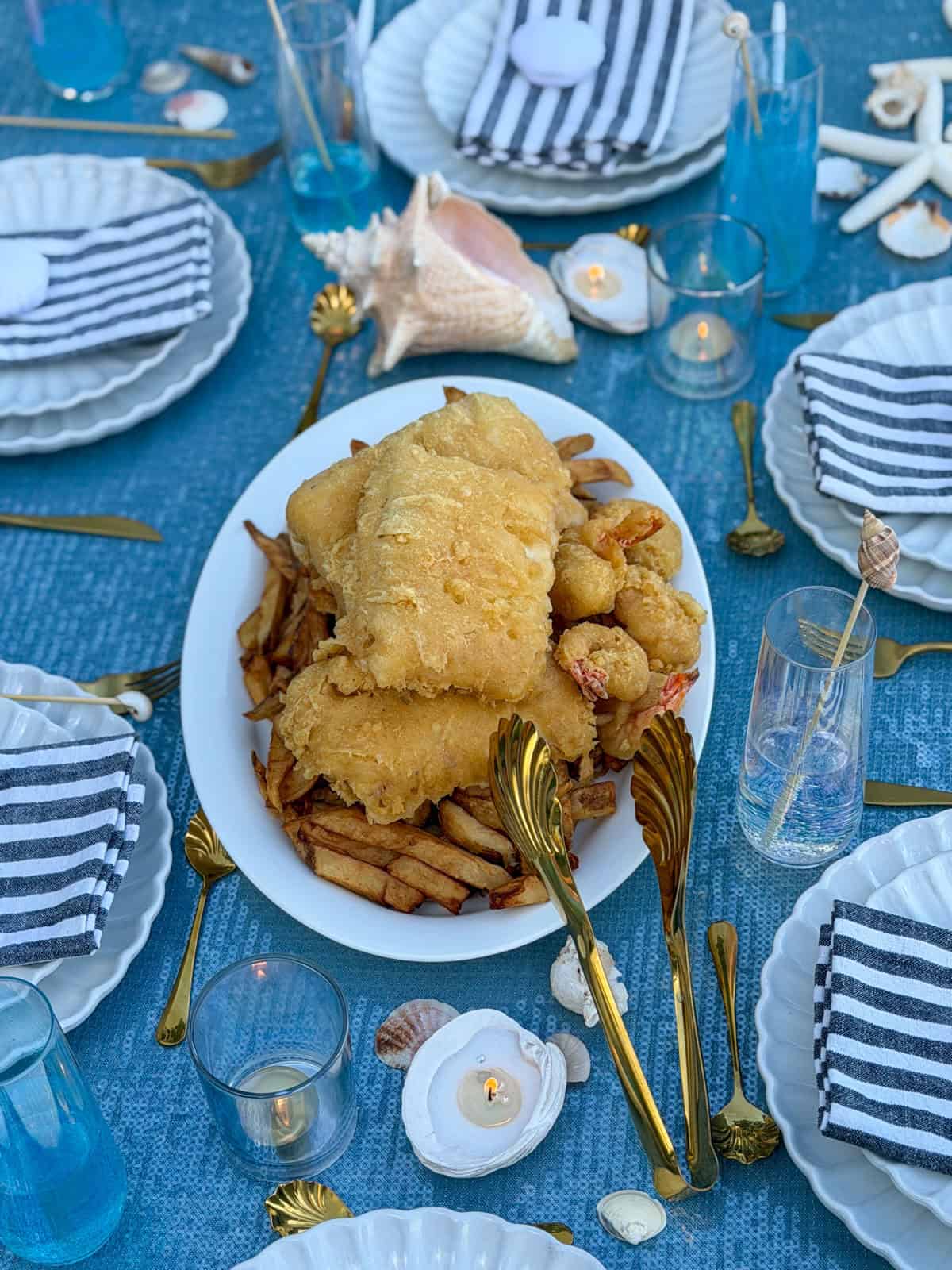 Overhead platter of fish, shrimp, and chips on the party table.