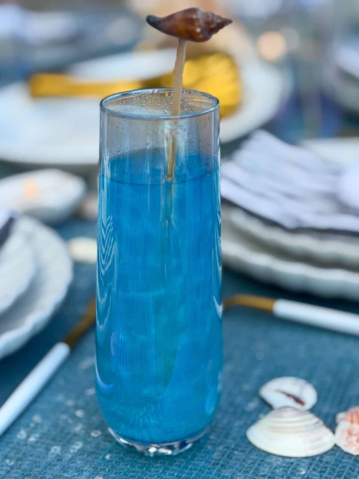 Blue mermaid mocktail with seashell stir stick.