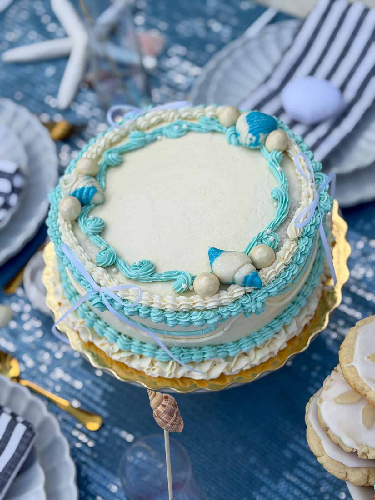 White and turquoise mermaid cake decorated with pearls and seashells.