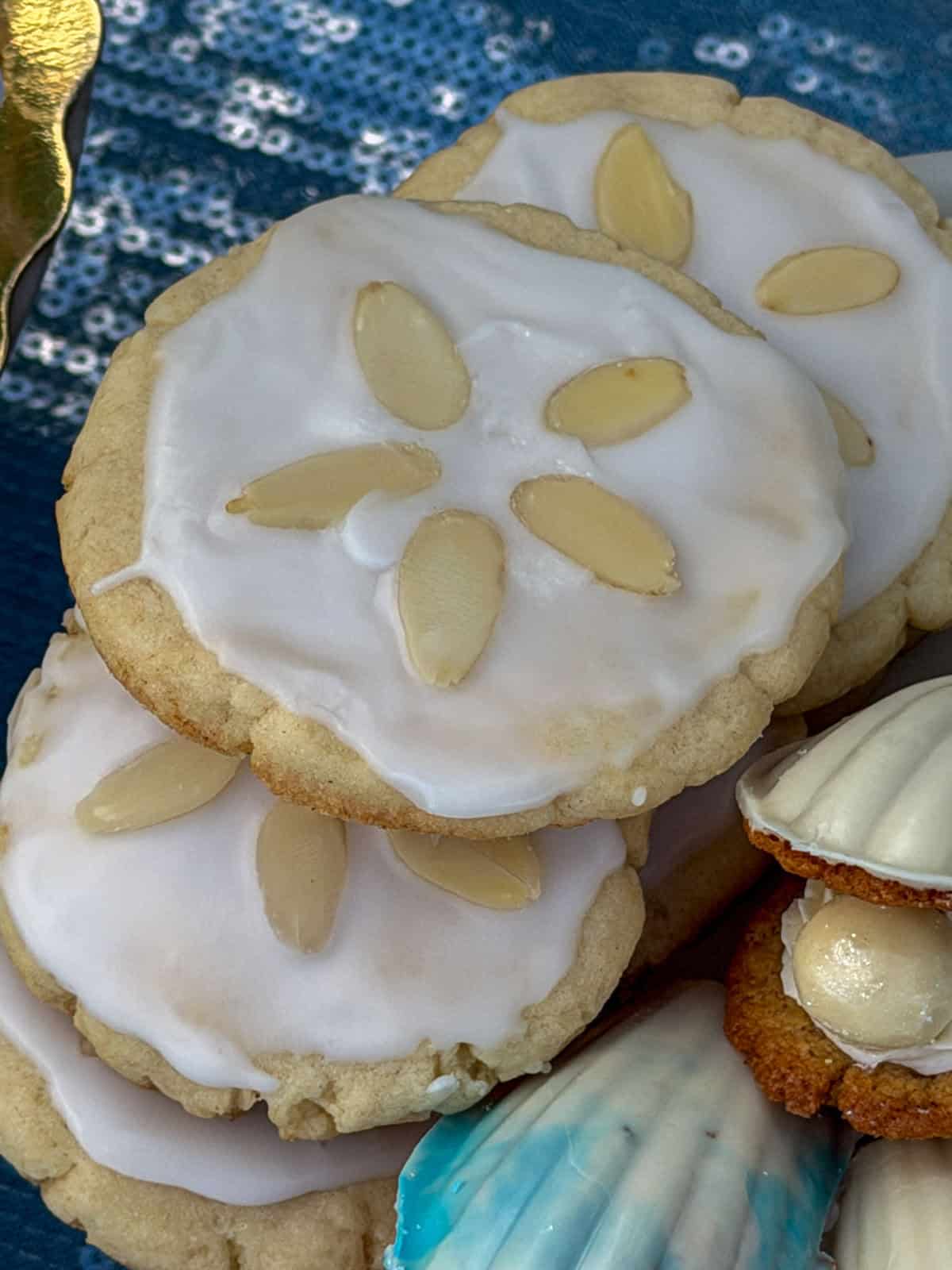 Almond sand dollar cookies with sliced almonds on a plate.