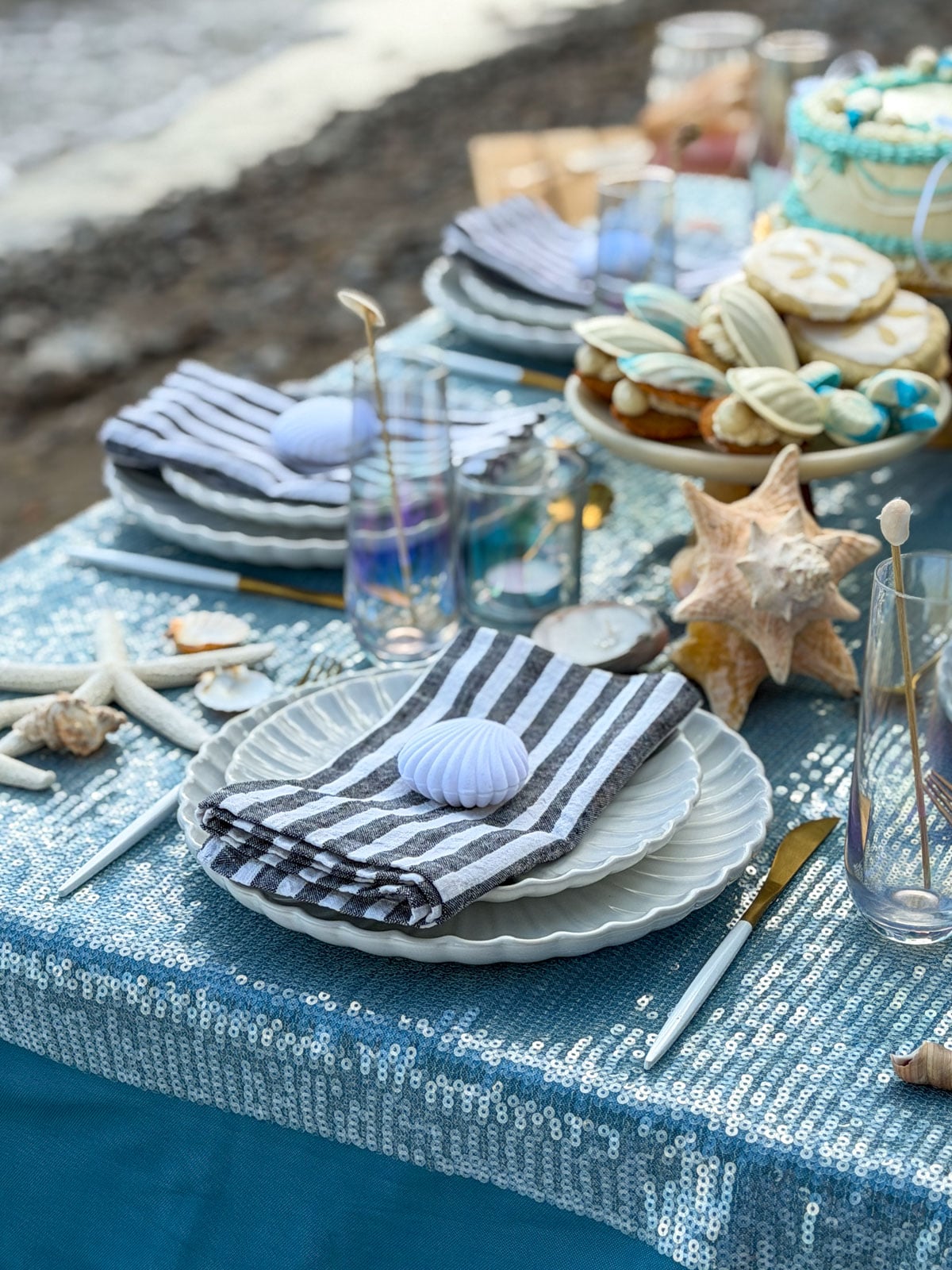 Scalloped plate place setting with starfish and seashells.