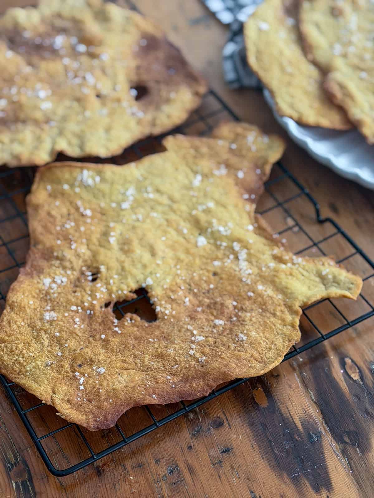 Crisp baked flatbread crackers cooling on a wire rack, ready to store in an airtight container.
