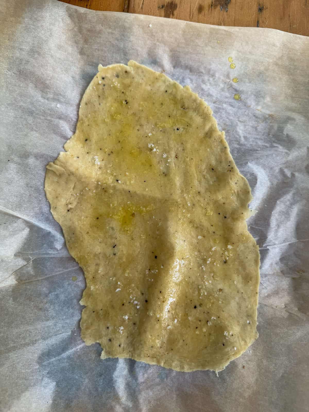 Rolled cracker dough brushed with olive oil and topped with flaky salt before baking.