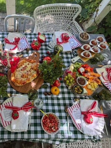 Overhead view of tomato party table with pizza and appetizers.