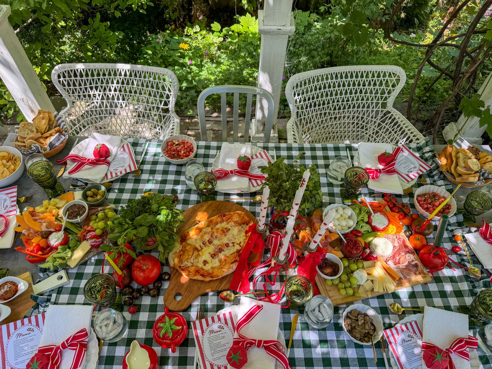 Overhead view of tomato party table with pizza and appetizers.