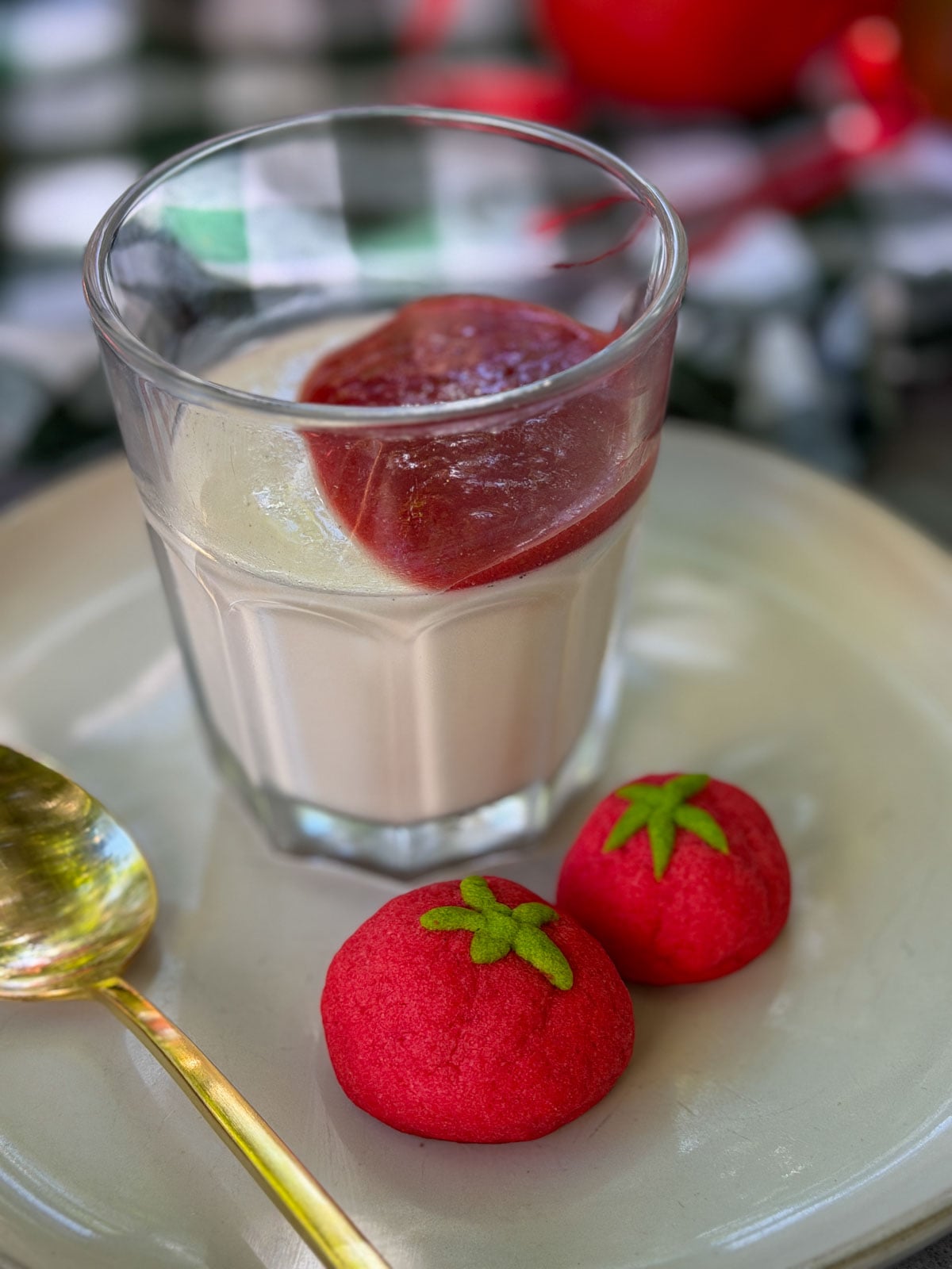 Panna cotta with strawberry sauce and tomato shaped cookies as a tomato themed dessert for a tomato party.