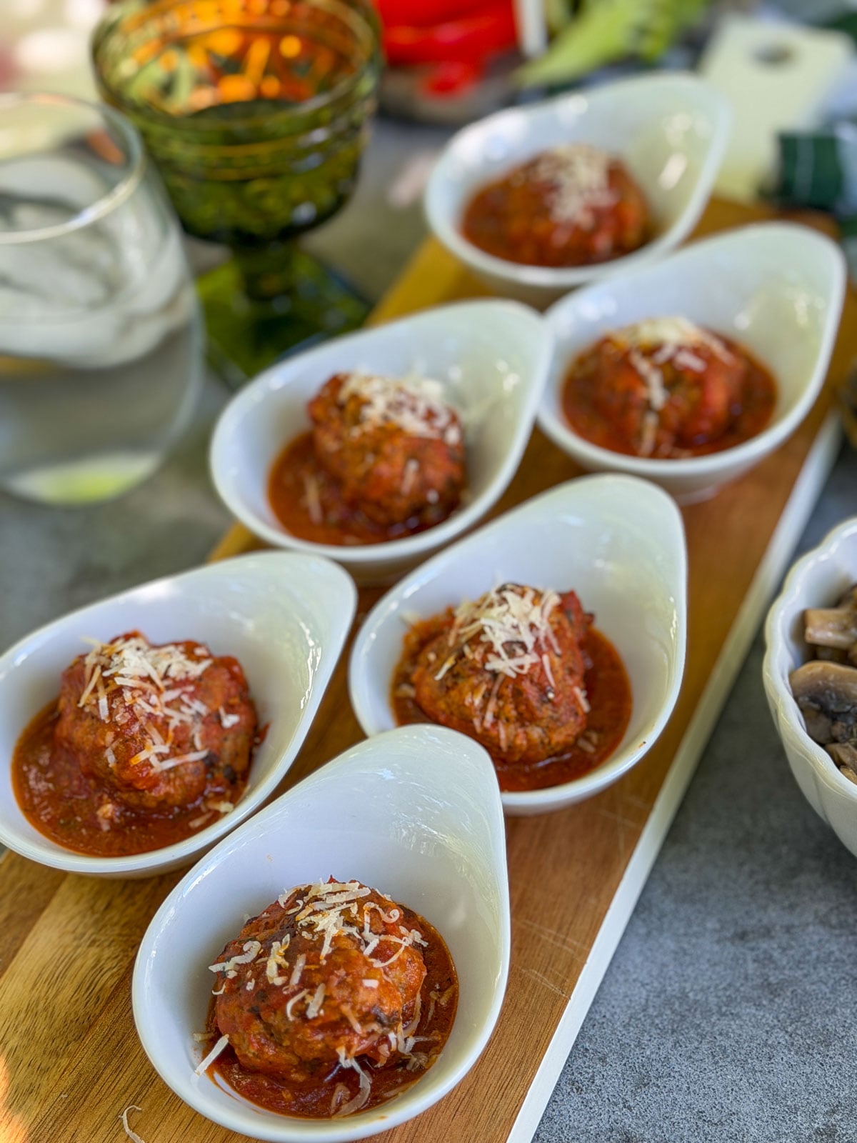 Individual meatballs in tomato sauce with parmesan.