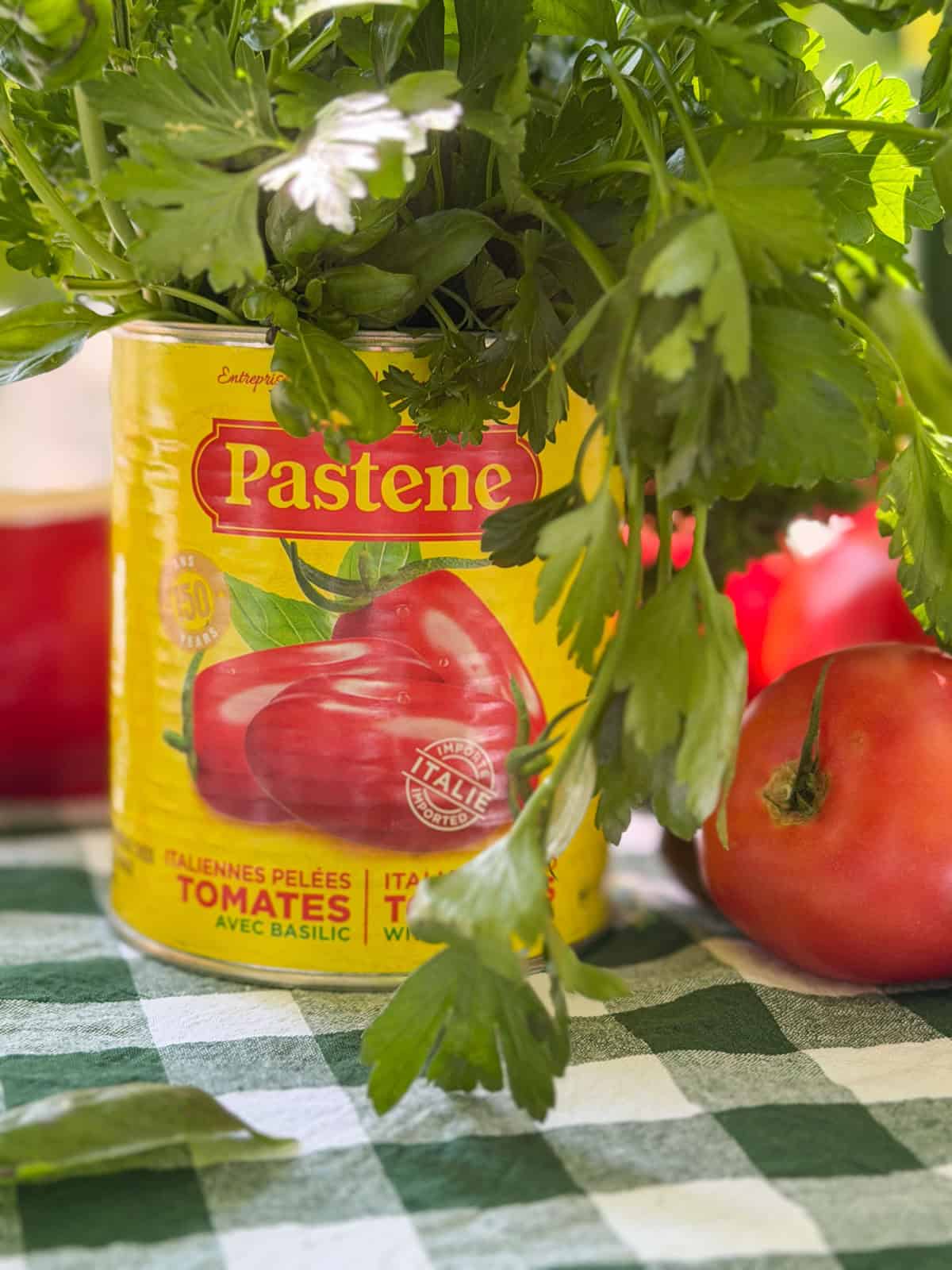 Fresh herbs in upcycled yellow Italian tomato can vase.