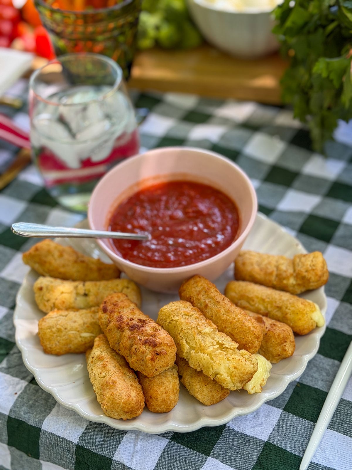 Mozzarella sticks with marinara dipping sauce on plate.