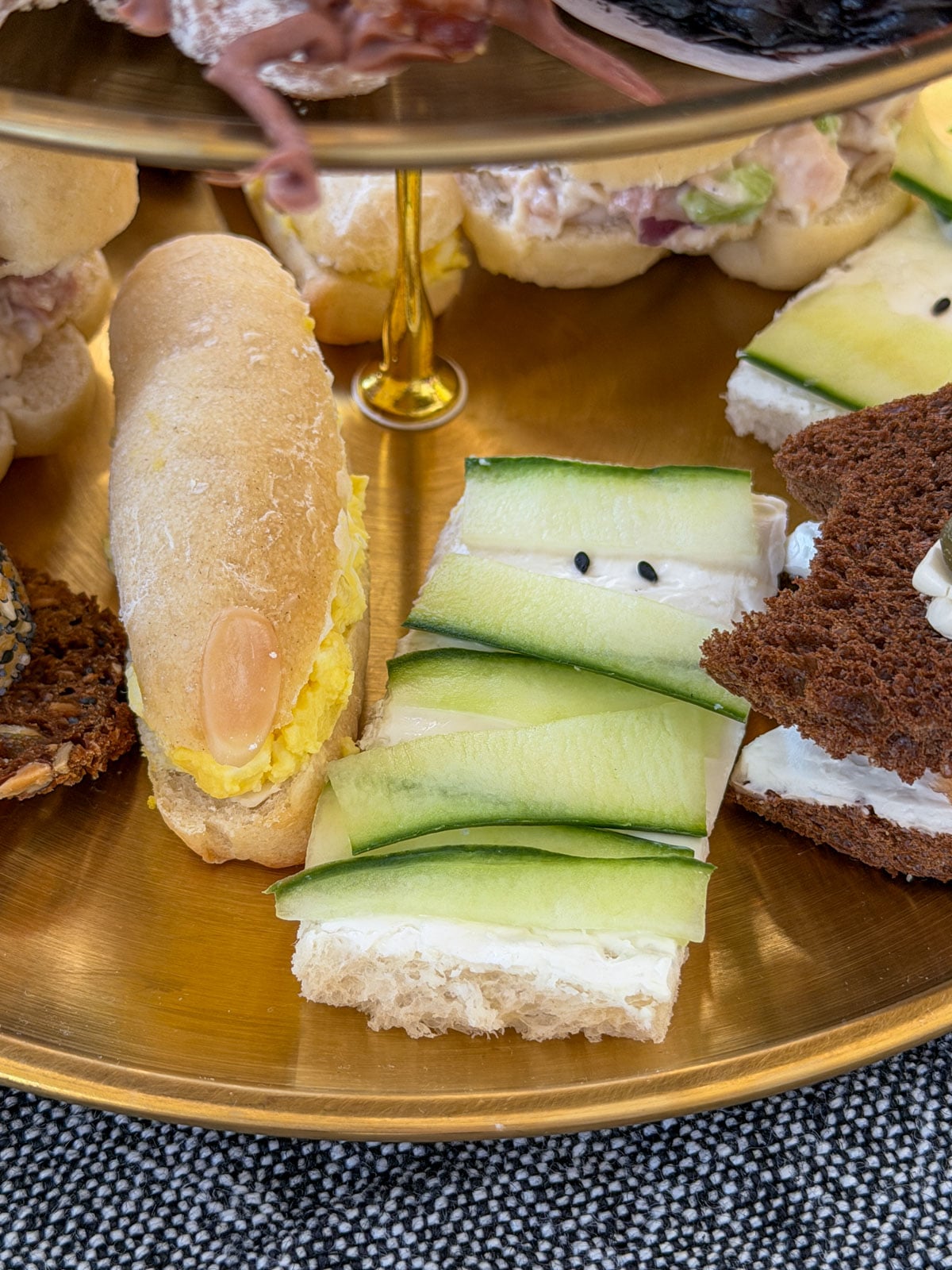 Open faced cucumber sandwiches wrapped in cucumber ribbons to look like mummies.