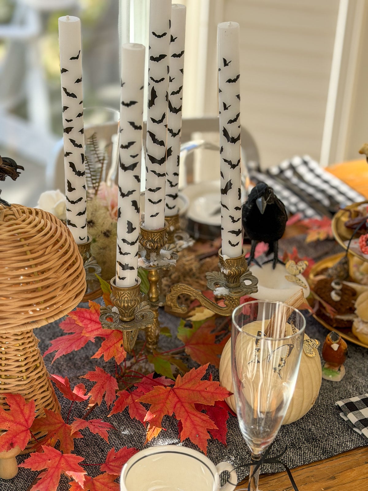 Black bat patterned taper candles in a brass candelabra.
